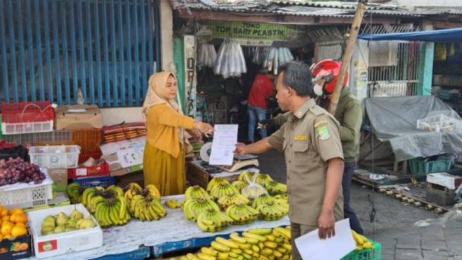 Petugas Tramtib Kecamatan Tangerang menyebarkan surat edaran kepada PKL yang masih berjualan di ruas-ruas jalan sekitar Pasar Anyar Tangerang