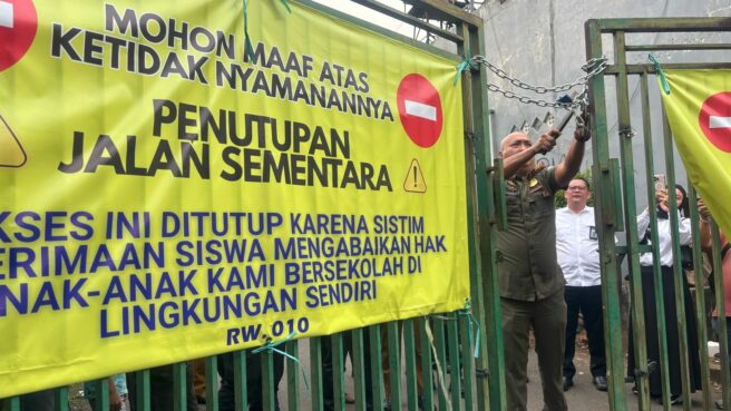 Petugas gabungan saat membongkar akses penutup menuju SMPN 17 dan SMAN 6 Tangsel, Senin (14/7). Foto: Andre Pradana/Tangselife