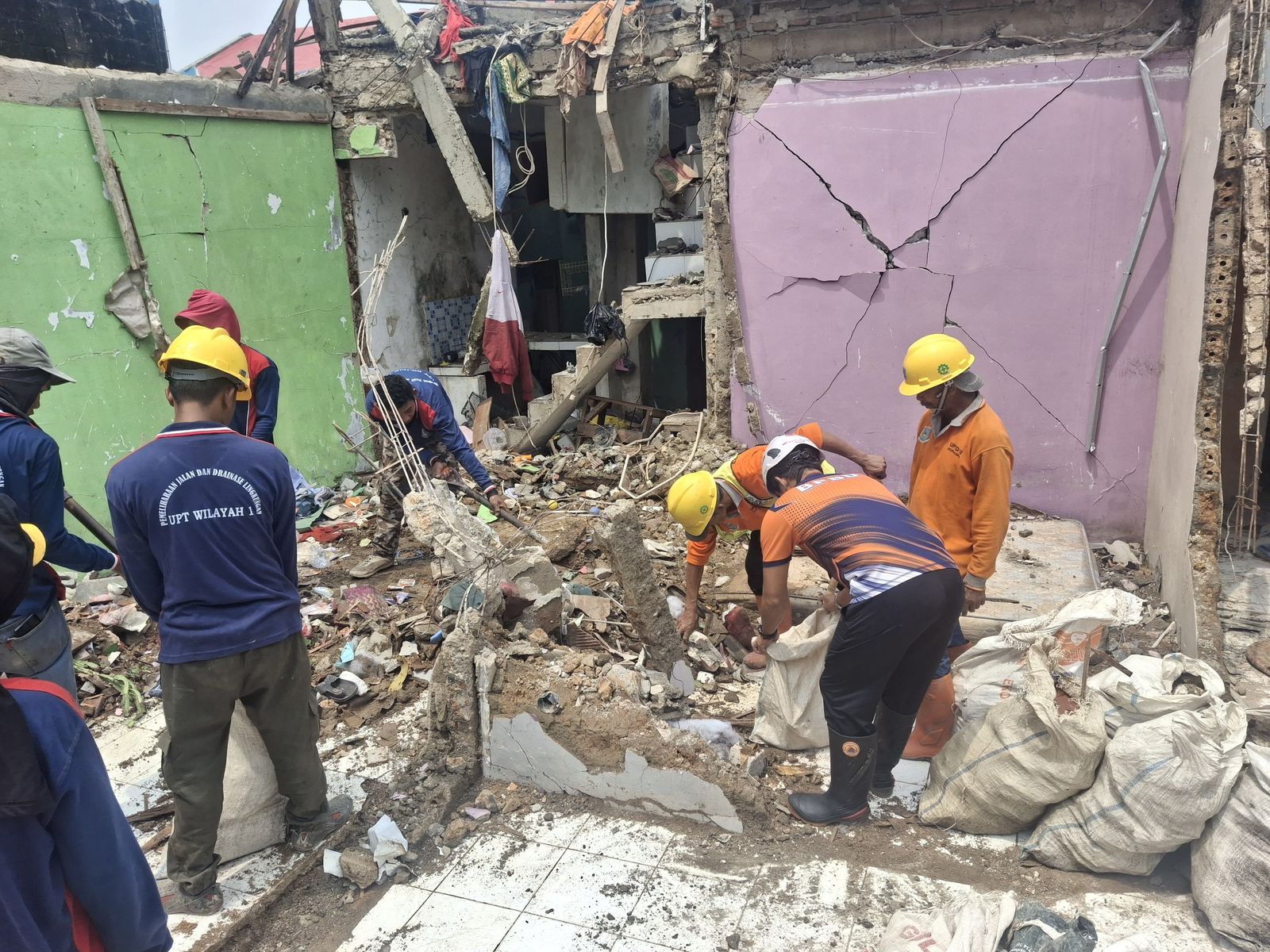 Para petugas gabungan bergotong royong membersihkan puing sisa ledakan di Pondok Cabe. Foto: BPBD